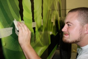 Jarrod looking closely at wrap while pressing squeegee